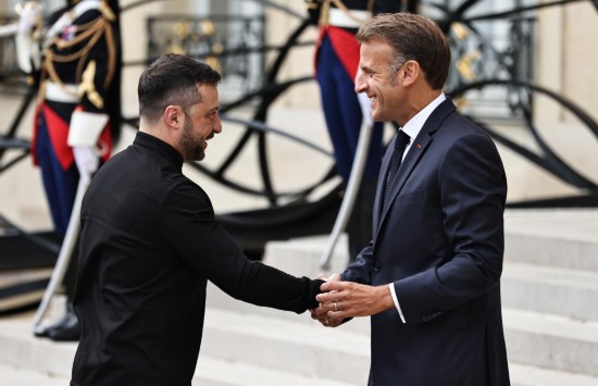 2025年9月4日，在法国首都巴黎的总统府爱丽舍宫，法国总统马克龙（右）迎接出席“志愿联盟”线上会议的乌克兰总统泽连斯基。新华社记者高静摄