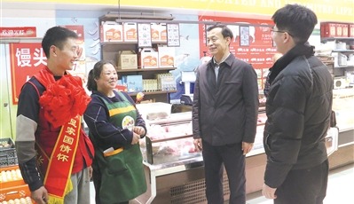 12月19日，威海高新区管委会工作人员来到小亮果蔬超市，为韩亮亮佩戴红花与绶带。曲  峰摄