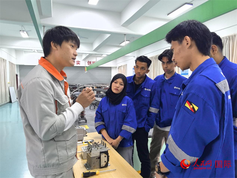 图为柳铁职院铁道机车运用与维护专业老师颜瑞（左一）正在向哈娜（左二）和她的同学们讲解设备的工作原理。人民网记者 付华周摄