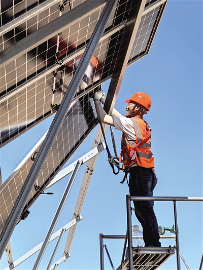 工人在安装光伏板。
