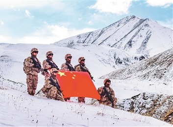 抵达目的地后,巡逻官兵与国旗合影。