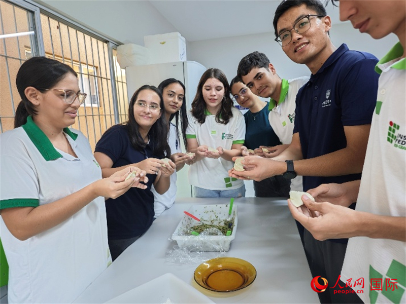 在巴西北里奥格兰德州联邦教育科技学院，中巴科技小院成员正在教巴西学生包饺子。人民网 安德烈·R·P摄