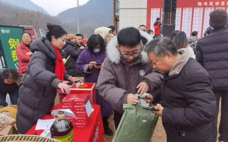神农架阳日镇的年货集市上湖北银行神农架支行工作人员引导村民扫码答题兑换礼品。