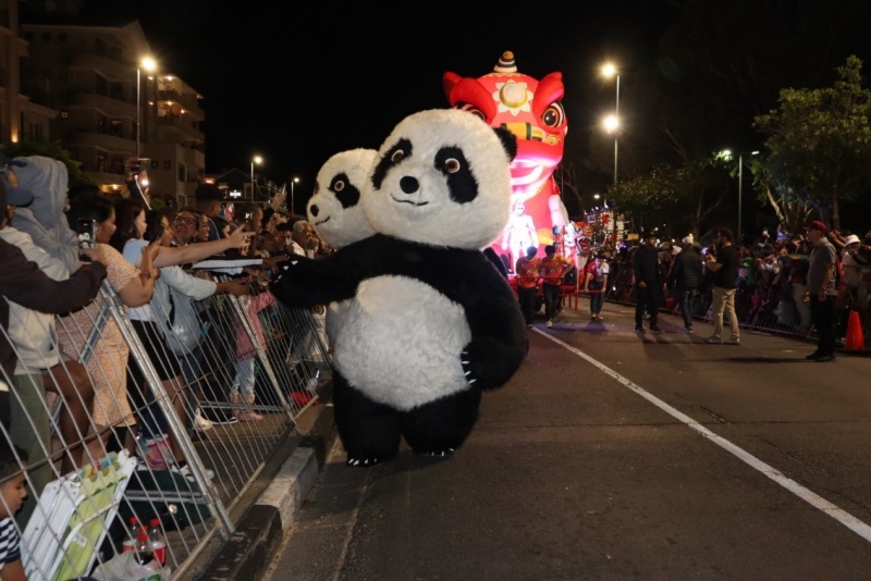 大熊猫玩偶与沿街民众热情互动。南非开普敦华星艺术团供图